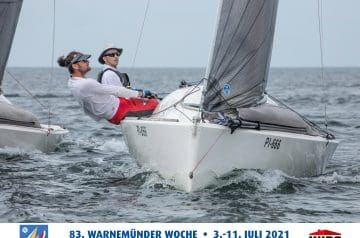 Zwei Männer spielen auf einem weißen Segelboot während eines Segelrennens auf dem Meer, tragen Sonnenbrillen und Hüte, im Hintergrund ein weiter offener Himmel und Wasser, auf einem Ankündigungsbanner für die Veranstaltung "83. WARNEMÜNDER WOCHE" vom 3. bis 11. Juli 2021.